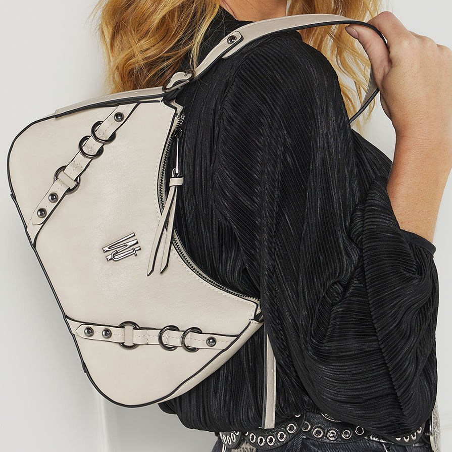 Bolsa baguete off white usada no ombro mostrando formato curvo e zíper superior
